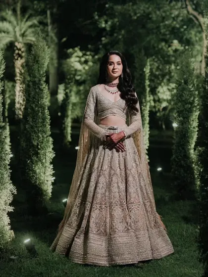 The bride poses in an enchanted garden setting, her sparkling Falguni Shane Peacock lehenga creating a magical, fairytale look for her sangeet night.