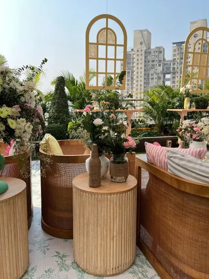A close-up of the earthy and natural decor, with wooden tables, cane sofas, and fresh floral arrangements in glass vases.