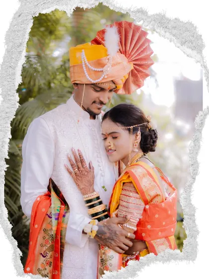An artistic portrait with a torn-paper effect, focusing on the couple's embrace and the bride's henna-adorned hand.