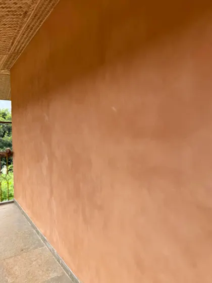 A close-up view of the smooth, even finish of the lime plaster texture on an exterior wall. The quality of the application is clear in the seamless surface.