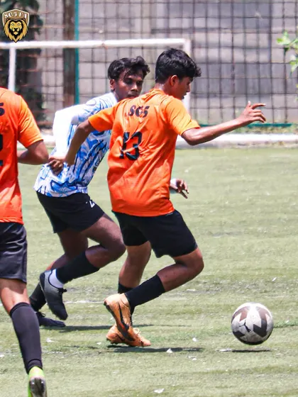 A player in our orange kit navigating through midfield during the match against Springfield FC.