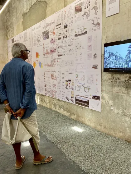 A visitor observing a student's detailed presentation board.