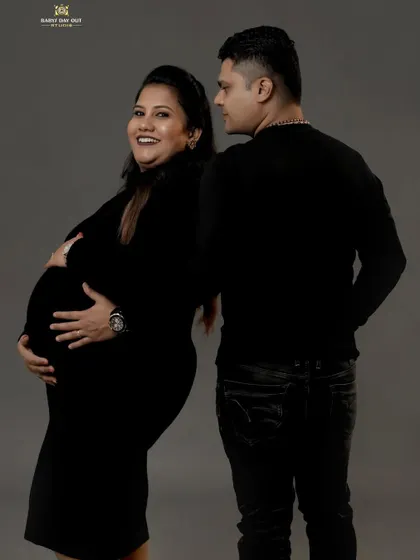 A candid and joyful moment captured in the studio. The mom-to-be's happy expression and the partner's loving gaze make this a truly special memory.