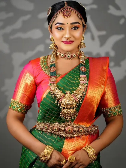 The complete bridal look, showing how the traditional hairstyle, heavy gold jewelry, and vibrant silk saree come together to create a breathtaking appearance.