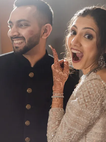 A fun, goofy moment as the bride points to a lipstick mark on the groom's cheek. This is the authentic, playful love we love to document.