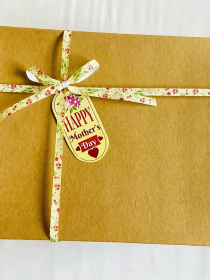 The simple, rustic packaging for our Mother's Day bakery box, tied with a floral ribbon and a 'Happy Mother's Day' tag.