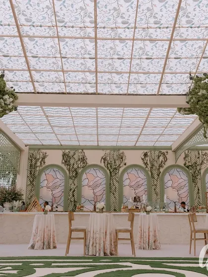 A wide shot of the main bar and pergola structure. The design uses lattice work and a patterned ceiling to create a sense of being in a beautiful, open-air conservatory.