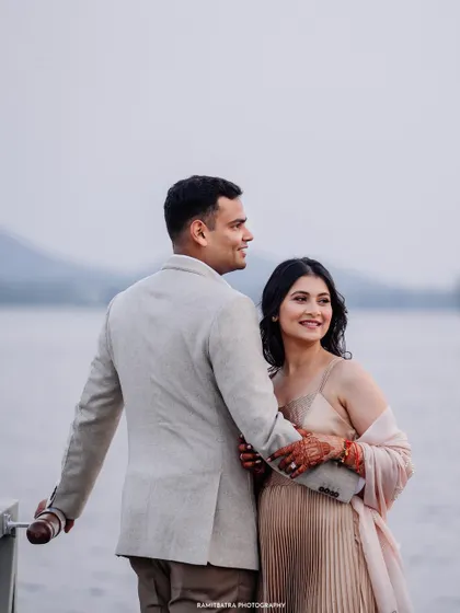 A sweet and candid moment of the couple enjoying the view from the deck at Raffles Udaipur.