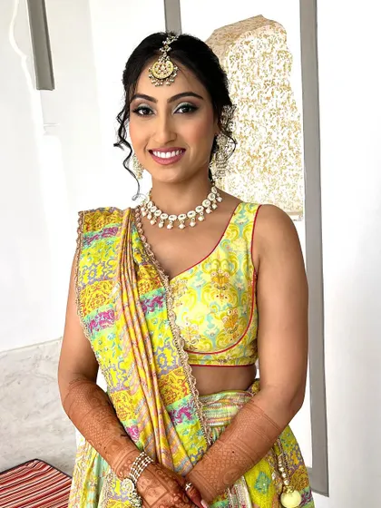 Another angle of this stunning Mehendi look. The makeup is subtle, with a focus on glowing skin and defined eyes, letting her natural radiance shine through.