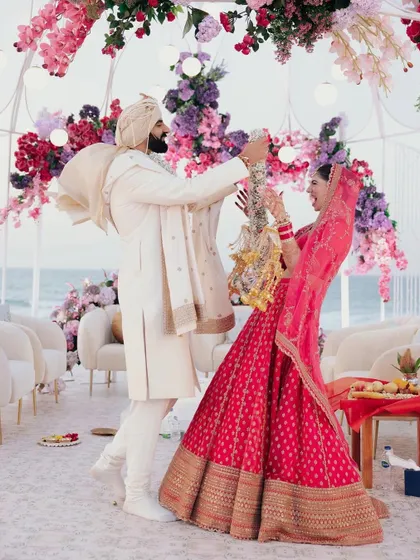 The playful and joyous Varmala exchange between Akanksha and Yash at their Abu Dhabi beach wedding. The happiness in this moment is contagious.