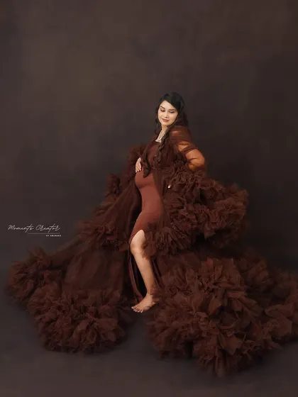 A powerful pose in a dramatic brown gown. The flowing fabric and confident stance create a striking and artistic solo maternity portrait.