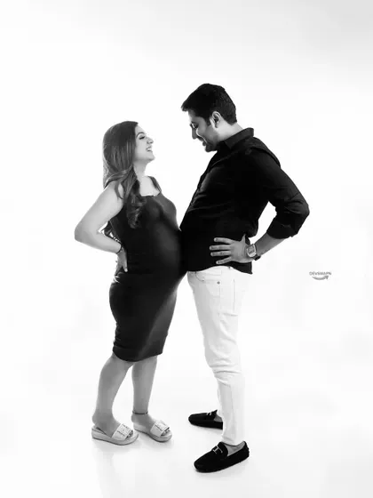 A black and white version of a playful 'bump to bump' pose. Monochrome often enhances the emotional and fun connection between the couple, creating a timeless and joyful image.