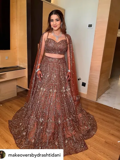 Another full-length view of this breathtaking Sangeet look. The makeup is bold enough to stand up to the sparkle of her outfit but still feels elegant.