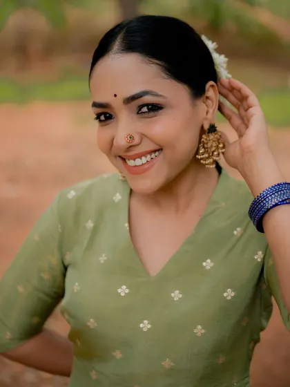 A joyful and candid portrait of actress Anupama Gowda. Her natural smile and the soft lighting create a warm and inviting image.