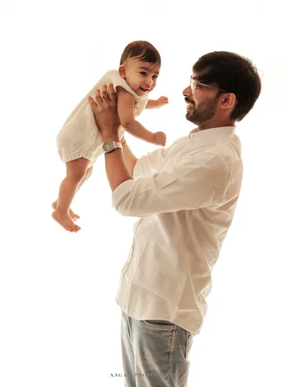 A father playfully lifts his laughing baby in the air. This high-key shot is full of energy, joy, and pure love.