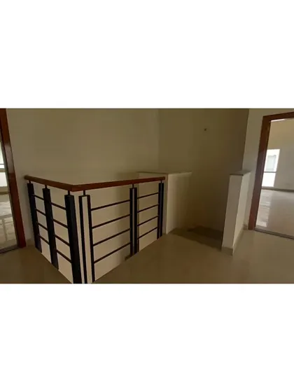 **BEFORE:** The original staircase landing, featuring a standard railing that felt heavy and enclosed the space.
