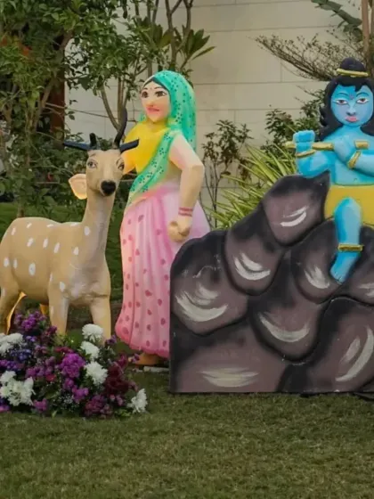 Props from our Krishna theme, including a deer and characters in traditional attire, set up outdoors for a garden party feel.