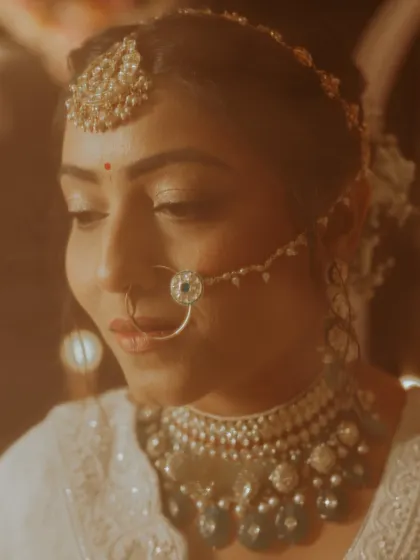 A close-up shot with a warm, dreamy filter, focusing on the bride's delicate features and stunning jewelry.