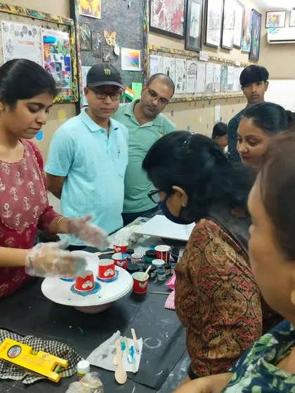 An instructor demonstrating a fluid art pouring technique to an attentive group of students. Our classes are interactive, with plenty of opportunities for questions and guidance.