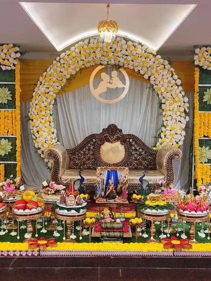 A baby shower setup with a yellow marigold checkerboard backdrop and a floral arch, creating a sunny and festive look.