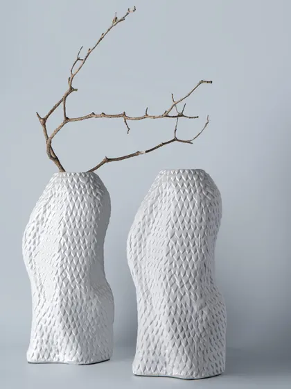 The human form inspires these two sculptural vases, with their gentle curves and textured, diamond-patterned surface. Paired with stark branches, they create a beautiful contrast between soft shapes and sharp lines.