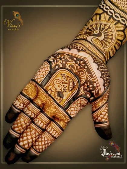A close-up of a family member's mehndi, featuring an elephant in a traditional frame and a peacock motif.