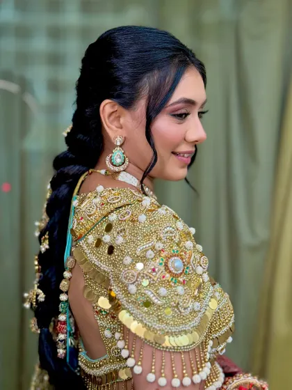 A side view of the Haldi look, showing the intricate braid and heavy gold embroidery on the blouse.