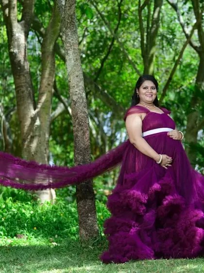 This wine-colored ruffle gown is perfect for an outdoor maternity shoot. The long, flowing tail creates a beautiful contrast against the natural greenery, adding a touch of magic to your photos.
