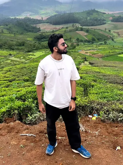 Standing on a viewpoint overlooking the vast tea plantations of Ooty. The scale of the landscape is breathtaking.