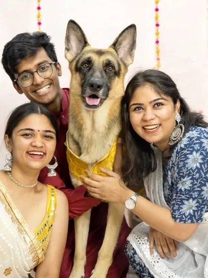 A beautiful family portrait celebrating a festival together. This German Shepherd looks so proud to be included in the festivities with his loving family, all dressed in traditional attire.