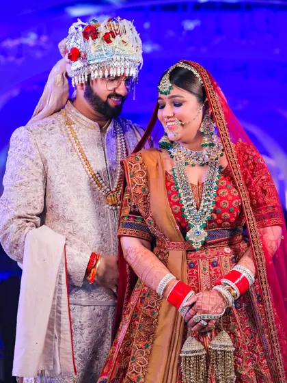 A sweet, candid moment with the groom looking lovingly at his bride. Her shy smile and their traditional attire make this a heartwarming wedding portrait.