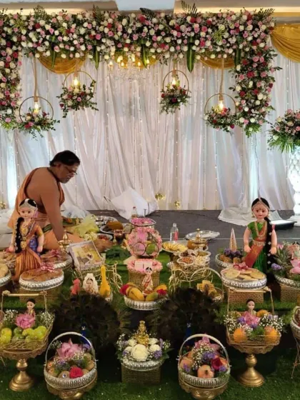 An engagement ceremony in progress, showing the decorated stage with traditional dolls and platters as part of the setup.