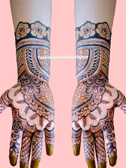 This design features a prominent arch pattern on the back of the hand, filled with delicate details and topped with a floral cuff. The use of blue and black henna adds a modern twist.