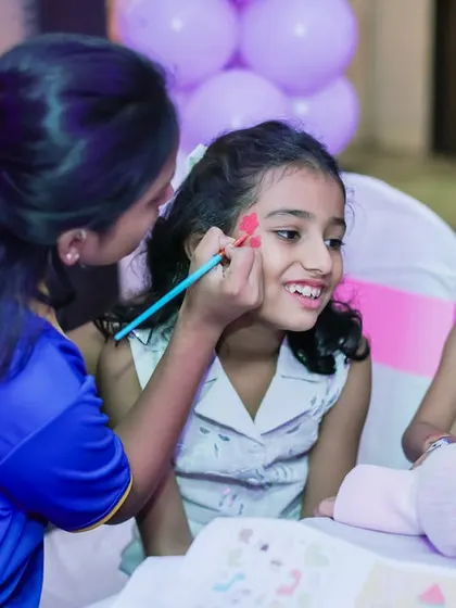 A happy girl getting her face painted. Face painting is a classic party activity that transforms kids into their favorite characters or animals.