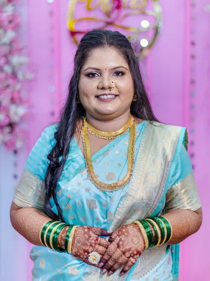 A happy, smiling close-up of the bride-to-be. This shot highlights the flawless makeup application, from the smooth base to the defined eyes and the traditional bindi, all coming together for a perfect engagement look.