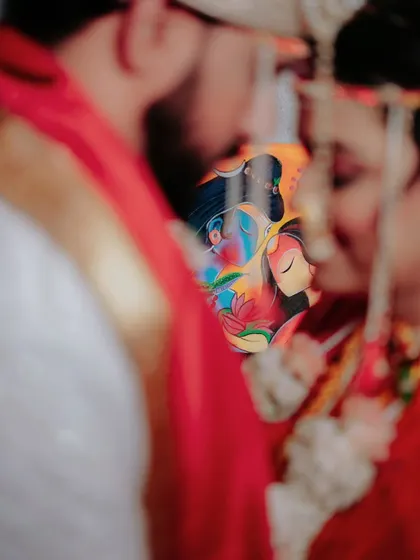 An artistic, soft focus shot capturing the couple's closeness, with a beautifully painted fan adding a unique, colorful element to the frame.
