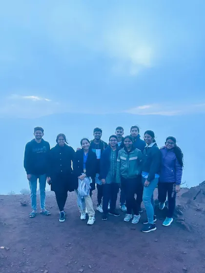 The group at a viewpoint just as the fog begins to clear, revealing the landscape.