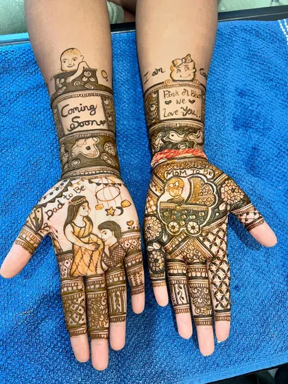 Mehendi is also for celebrating life's special moments. This custom baby shower design features portraits of the parents-to-be, a baby in a cradle, and messages like 'Coming Soon' and 'Pink or Blue, We Love You'.