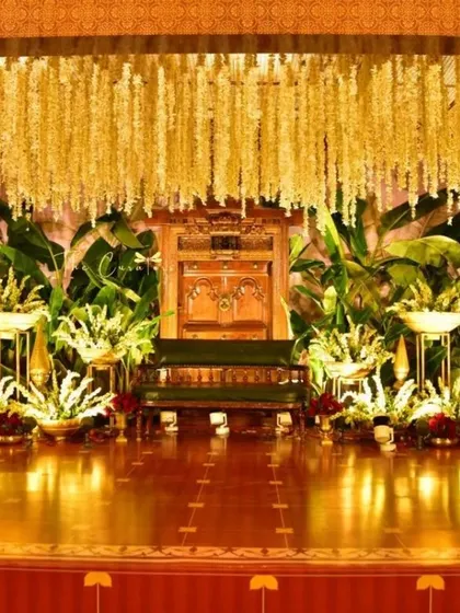 This angle showcases the grandeur of the stage, with its polished wooden floors reflecting the warm lighting and intricate floral arrangements.