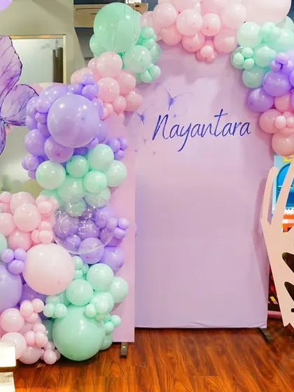 Our Fairy Garden theme entrance, featuring a stunning butterfly wing arch, a whimsical mushroom prop, and a beautiful arrangement of pastel balloons, sets a magical tone from the start.