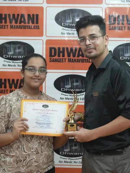 A teacher presents an award to his student.