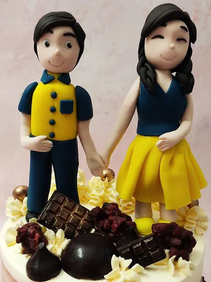 A close-up of our custom couple anniversary cake topper, showing a sweet, hand-in-hand moment captured in fondant.