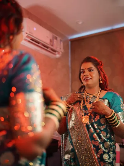 A candid shot of the reception bride getting ready, her makeup looking flawless in the mirror's reflection.