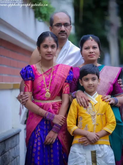 A formal family portrait taken during a cultural ceremony. The family is dressed in traditional attire, creating a stately and memorable image that honors the occasion.