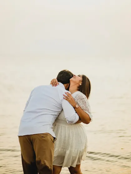 A moment of pure, uninhibited joy as the couple shares a laugh and a hug on the beach. This candid shot perfectly captures the fun and happiness of their relationship.
