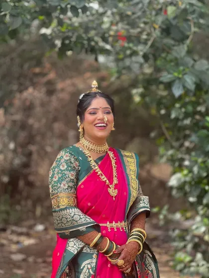 A happy bride in her pink and green Nauvari. The makeup is fresh and glowing, enhancing her natural beauty and joyful expression.