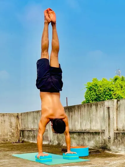 A perfectly aligned handstand on yoga blocks, demonstrating the upper body strength and balance that we build in my fitness sessions.
