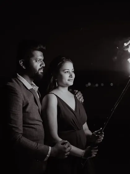 Another perspective of the dramatic fire torch pre-wedding shoot. This black and white image highlights the bride's profile and the flickering flame, creating a timeless and artistic portrait.