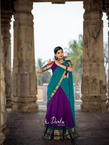A series of photos from a collaboration with a designer, showcasing a beautiful half-saree against the backdrop of ancient temple pillars. I love how the vibrant colors of the costume stand out.