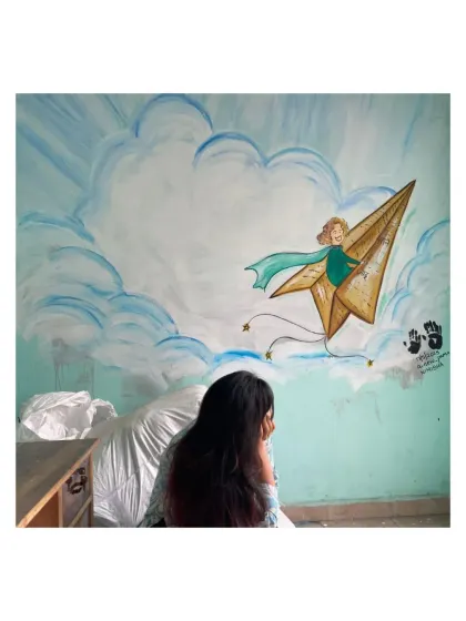 A girl on a paper plane, flying through the clouds. This mural, painted in a children's resource center, is a simple invitation to dream and imagine a world without limits.